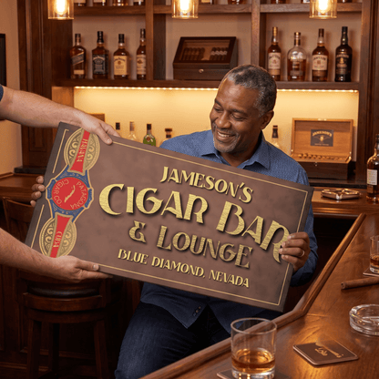 Man holding a personalized Cigar Bar Sign in a cozy home bar setting, featuring rich wood and whiskey décor.
